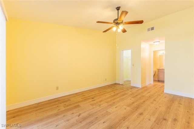 empty room with visible vents, baseboards, a ceiling fan, lofted ceiling, and light wood-style flooring