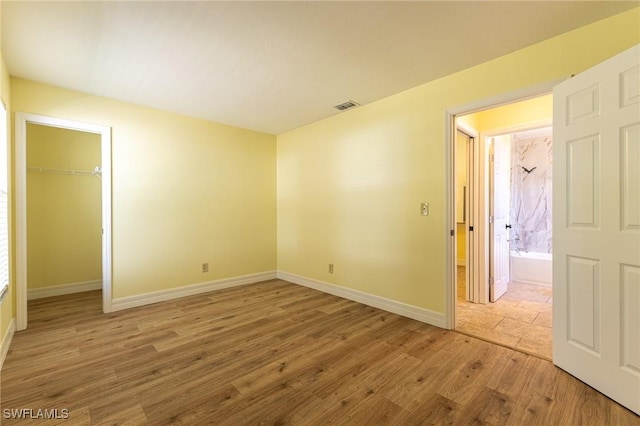 empty room with visible vents, baseboards, and wood finished floors