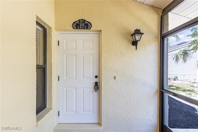 view of exterior entry featuring stucco siding