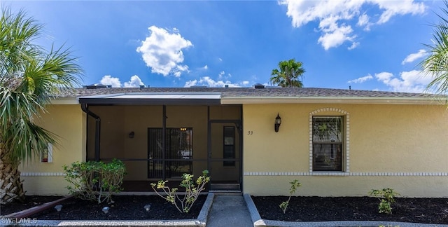 entrance to property featuring stucco siding
