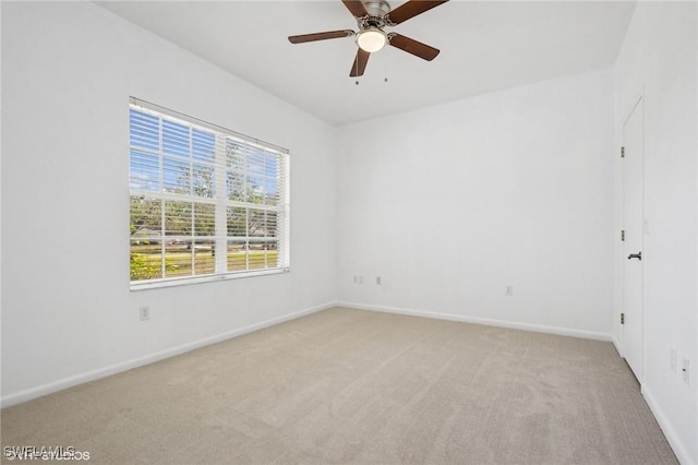 unfurnished room featuring ceiling fan, light colored carpet, and baseboards