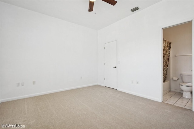 unfurnished bedroom with carpet flooring, visible vents, connected bathroom, and baseboards