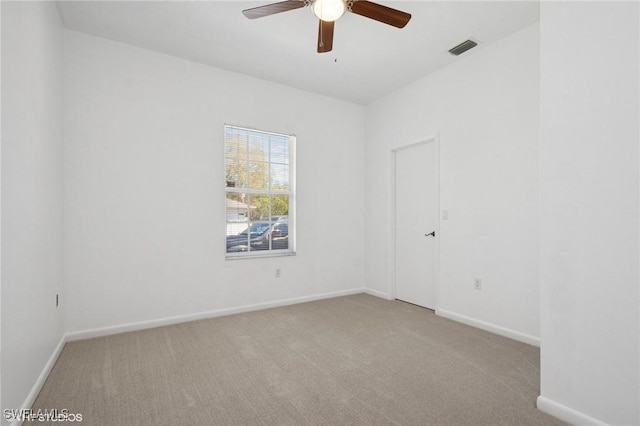 spare room featuring visible vents, a ceiling fan, baseboards, and carpet floors
