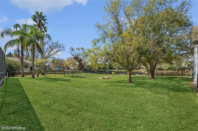 view of yard with a water view and a fenced backyard