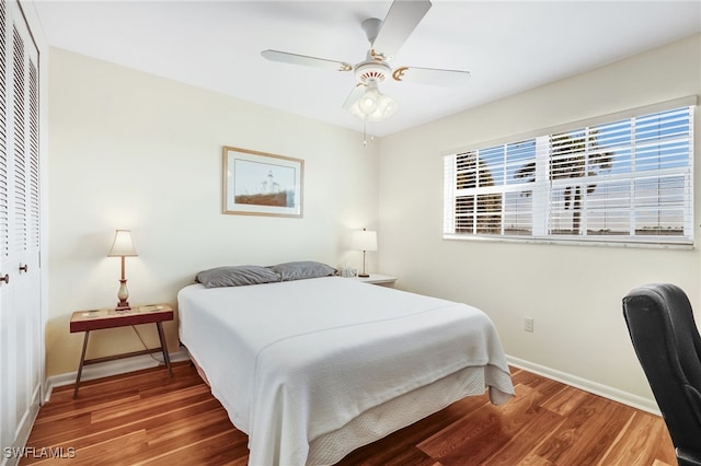 bedroom featuring a closet, ceiling fan, baseboards, and wood finished floors