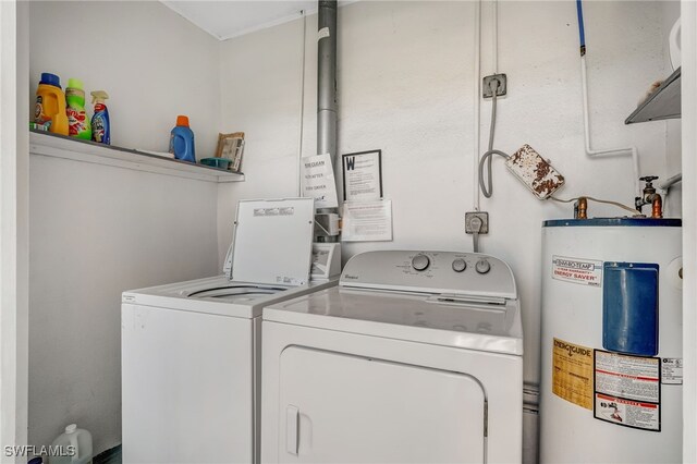 laundry area with laundry area, water heater, and washing machine and clothes dryer