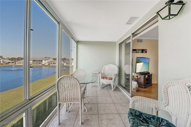 sunroom / solarium with visible vents and a water view