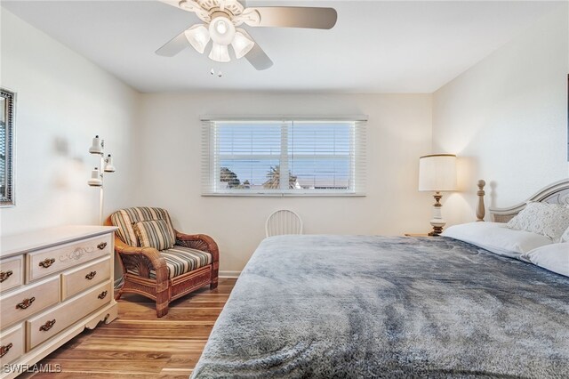 bedroom with light wood-type flooring, ceiling fan, and baseboards