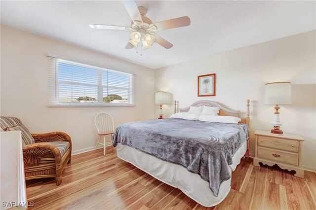 bedroom with a ceiling fan, light wood-type flooring, and baseboards