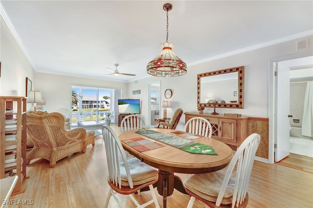 dining space featuring light wood-type flooring, visible vents, crown molding, and ceiling fan