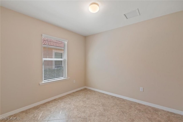 unfurnished room with light tile patterned flooring and baseboards