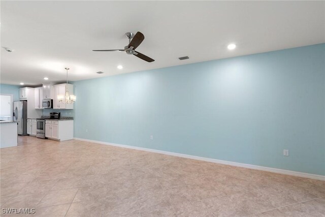 unfurnished living room with recessed lighting, visible vents, baseboards, and ceiling fan with notable chandelier