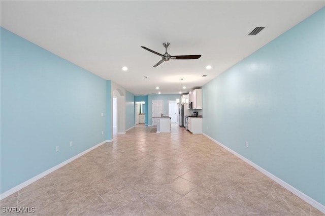 unfurnished living room with recessed lighting, visible vents, ceiling fan, and baseboards