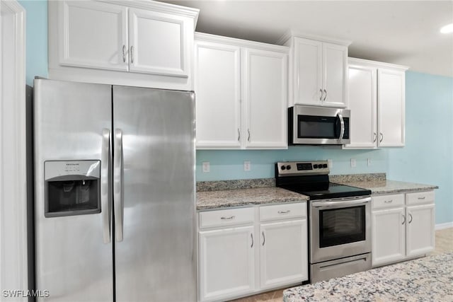 kitchen with white cabinetry, appliances with stainless steel finishes, and light stone counters