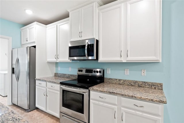 kitchen with white cabinets, light stone counters, and stainless steel appliances