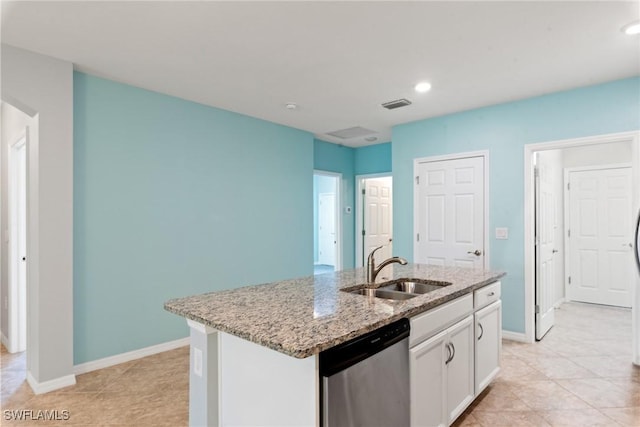 kitchen with light stone counters, a sink, visible vents, white cabinets, and stainless steel dishwasher