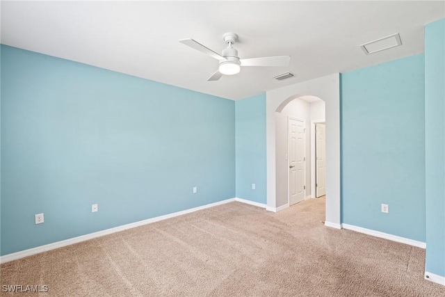 unfurnished room featuring baseboards, visible vents, arched walkways, a ceiling fan, and carpet flooring