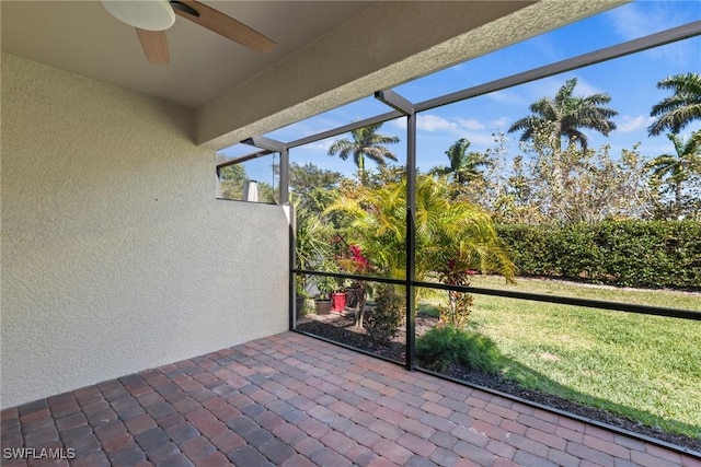 unfurnished sunroom featuring a ceiling fan