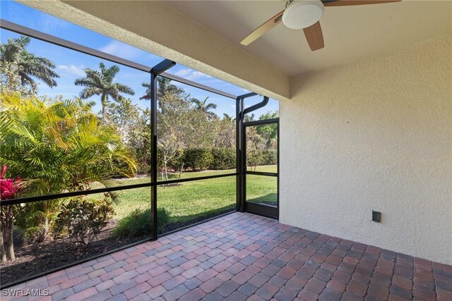 unfurnished sunroom with ceiling fan