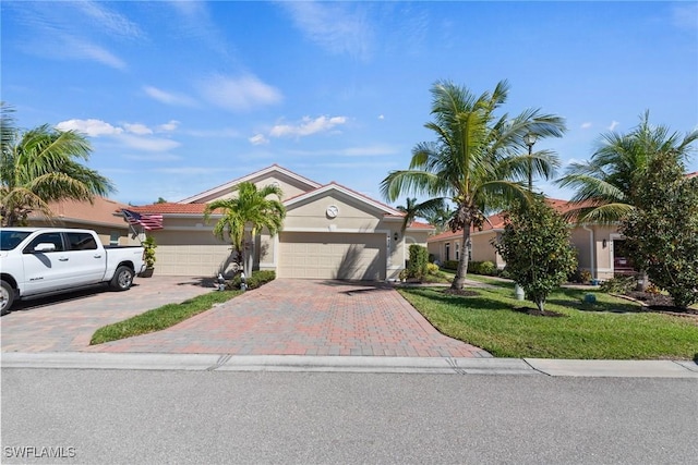 view of front of house with a front lawn, decorative driveway, an attached garage, and stucco siding