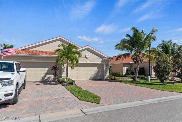 view of front of house with stucco siding, decorative driveway, and a garage