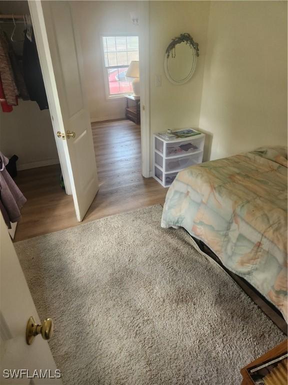 bedroom with a closet, a spacious closet, and wood finished floors