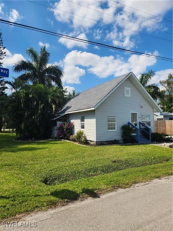 view of home's exterior featuring fence and a lawn