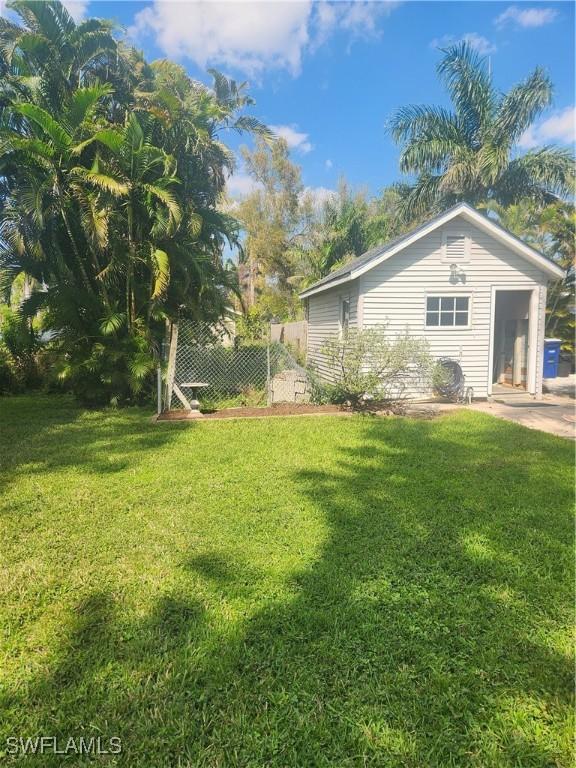 view of side of property featuring fence and a lawn