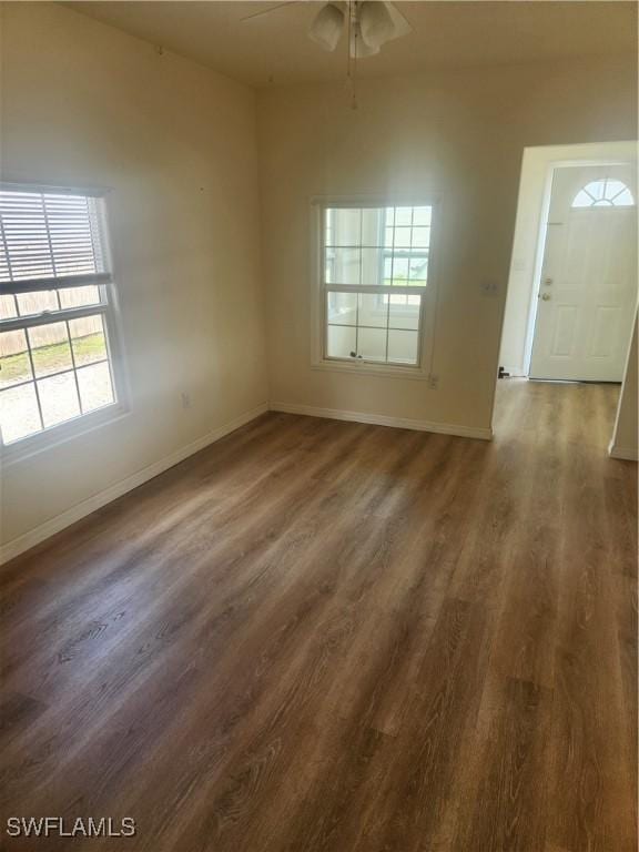 interior space featuring ceiling fan, baseboards, and wood finished floors