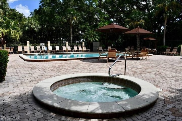 community pool with a community hot tub, a patio area, and fence