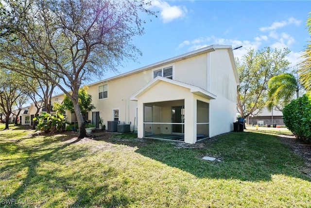 rear view of house featuring stucco siding, central AC unit, a yard, and a sunroom