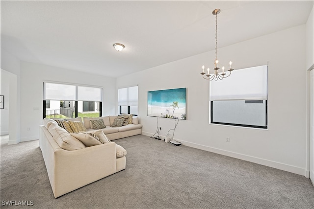 living area featuring baseboards, an inviting chandelier, and carpet floors