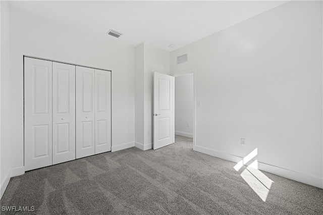 unfurnished bedroom with a closet, visible vents, carpet flooring, and baseboards