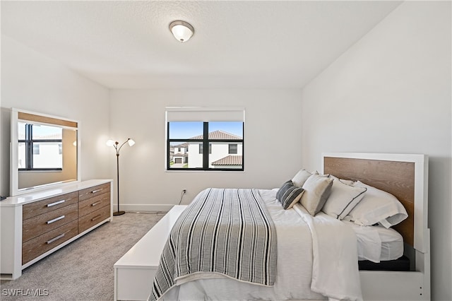 bedroom featuring baseboards, multiple windows, and light colored carpet