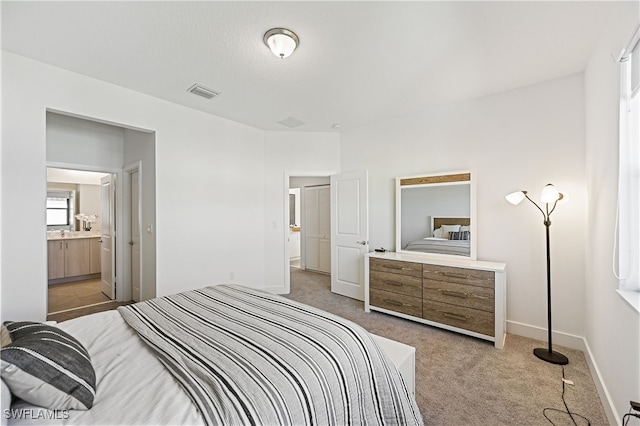 bedroom with visible vents, baseboards, ensuite bathroom, and carpet flooring