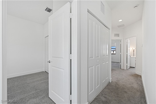 corridor featuring visible vents, baseboards, and carpet floors