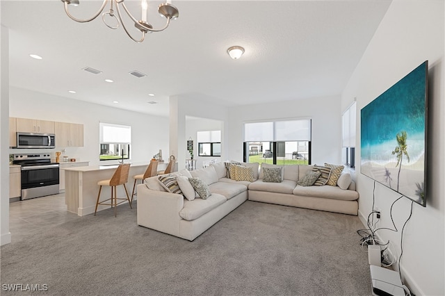 living area with visible vents, a wealth of natural light, and light carpet