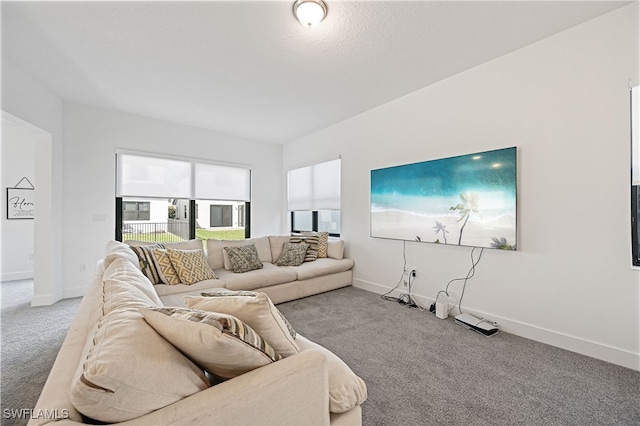 carpeted living area with baseboards