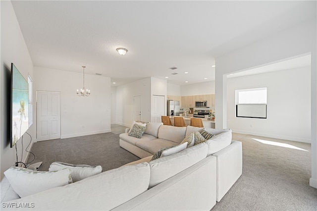 living area featuring recessed lighting, baseboards, light colored carpet, and an inviting chandelier