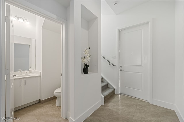 bathroom with tile patterned flooring, toilet, vanity, and baseboards