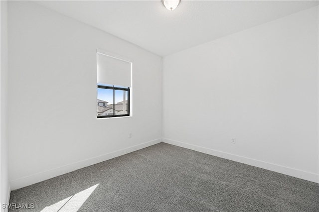 carpeted empty room with baseboards