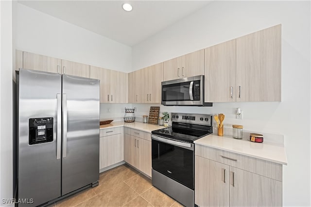 kitchen featuring appliances with stainless steel finishes, light brown cabinetry, and light countertops