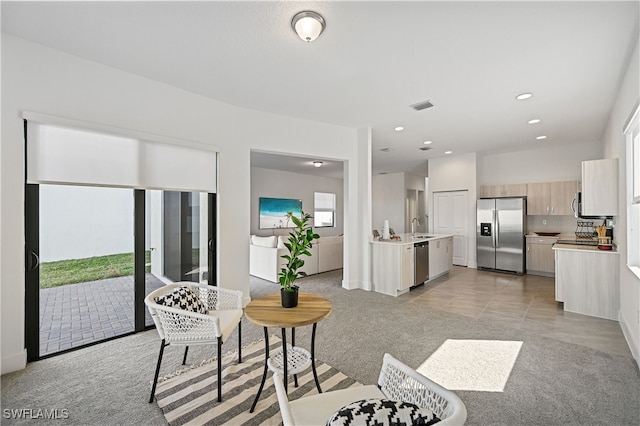 living room with recessed lighting, light colored carpet, and visible vents