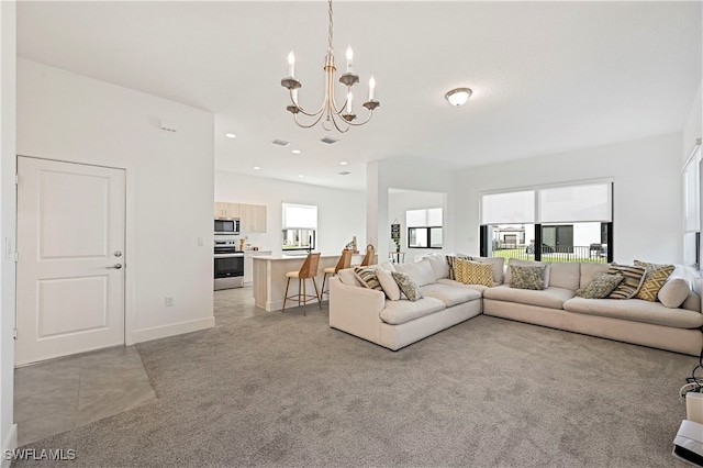 living room with visible vents, baseboards, recessed lighting, light carpet, and a notable chandelier