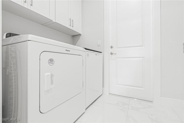 laundry room with marble finish floor, cabinet space, and washer and clothes dryer