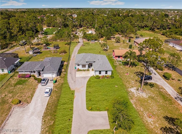 drone / aerial view featuring a residential view and a view of trees