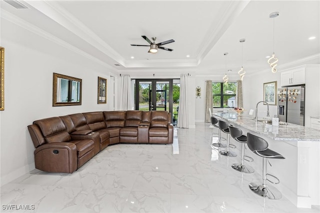 living room with a tray ceiling, french doors, marble finish floor, crown molding, and baseboards