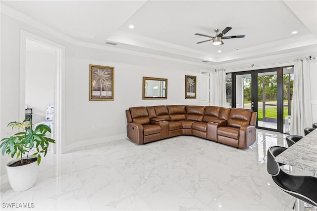 living room with a tray ceiling, recessed lighting, visible vents, ornamental molding, and baseboards