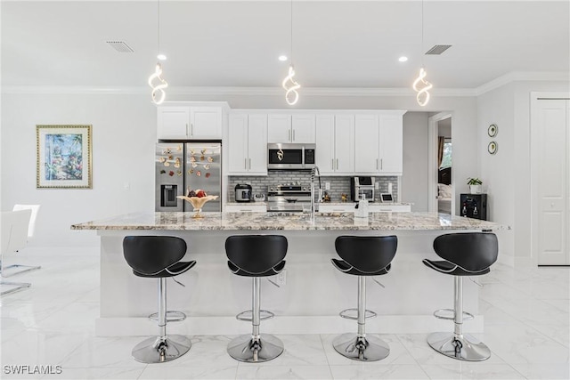 kitchen with appliances with stainless steel finishes, marble finish floor, a sink, and a breakfast bar area