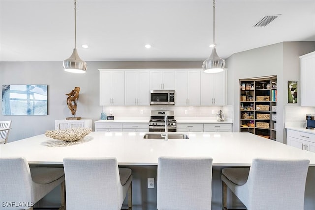 kitchen featuring stainless steel appliances, light countertops, visible vents, and tasteful backsplash